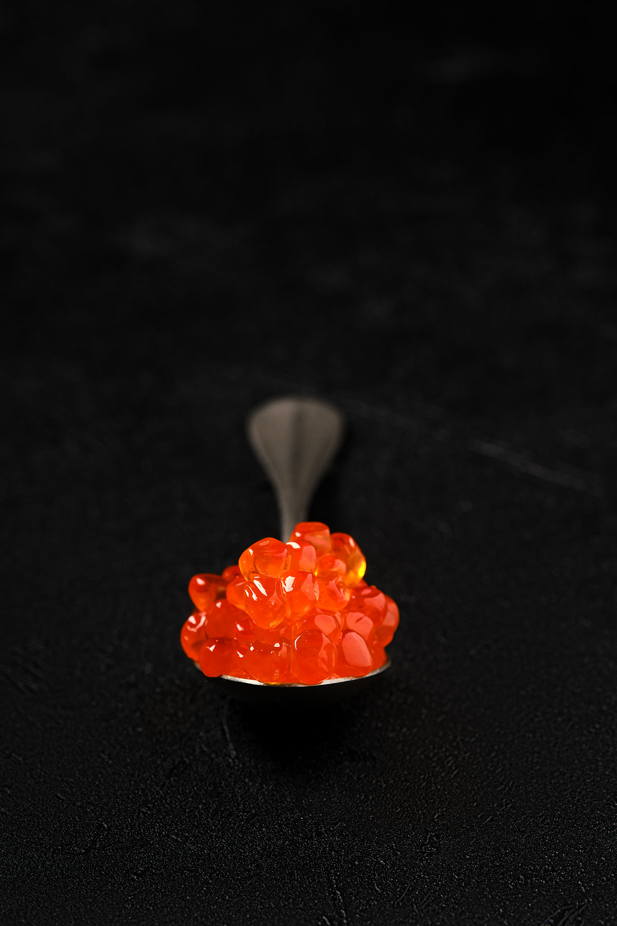 A spoon lifted with glistening salmon roe
